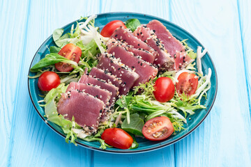Salad with raw tuna , sesame and cherry tomatoes photography . Top view