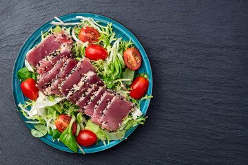 Salad with raw tuna , sesame and cherry tomatoes photography . Top view