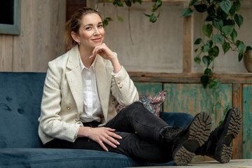 Businesswoman smiling and relaxing on sofa in modern office