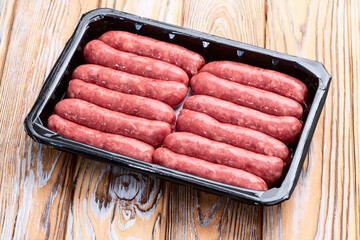 Raw beef sausages with rosemary and tomatoes photography . Top view
