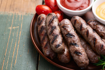 Grilled beef sausages with rosemary sauce and tomatoes photography . Top view