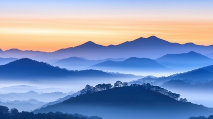 Fototapeta premium Serene sunrise over a mountain range with layers of mist creating a tranquil landscape. peaceful nature photography