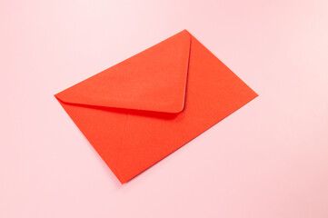 Top view of red envelope on pink background. Post flat lay. Copy space.