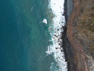 Aerial shot of a cliff, waves and the Atlantic Ocean from a 90° angle, Madeira coast, Portuguese...