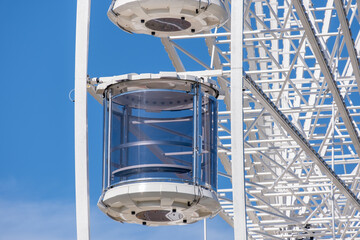 a transparent capsule or pod from a modern Ferris wheel or observation wheel, featuring a glass-enclosed cabin. Contemporary design of the amusement ride structure. © Doublelee