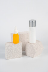 Plastic yellow tube for cream or lotion. Skin care or sunscreen cosmetic with stylish props on white background.