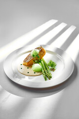 A beautifully plated salmon fillet, seared to perfection and served with tender asparagus spears. The dish is garnished with fresh herbs and a drizzle of citrus sauce