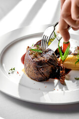 A close-up of a filet mignon, showcasing the tender and juicy meat. The dish is accompanied morels and a rich, creamy sauce, creating a delightful contrast of textures