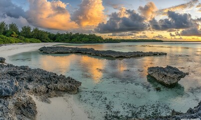 Obraz premium Tropical beach sunset with rocks and clouds
