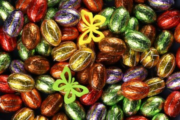Chocolate Easter eggs in foil with two felt butterfies. A treat for the Easter holidays.