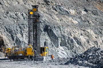 Open pit mine gold ore industry. Massive Mining Dump Truck and Drilling Equipment at Quarry Site © Parilov