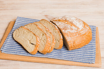 Assortment of freshly sliced baked bread with napkin on rustic table top view. Healthy unleavened bread. French bread slice