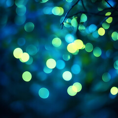 Obraz premium Magical blue and green bokeh lights create an enchanting atmosphere in a garden at twilight