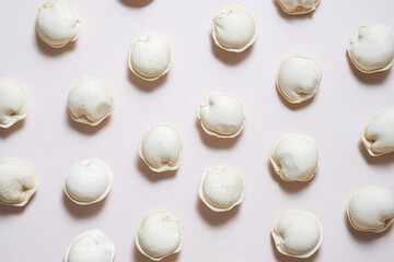 Flat lay of frozen dumplings arranged on neutral surface.