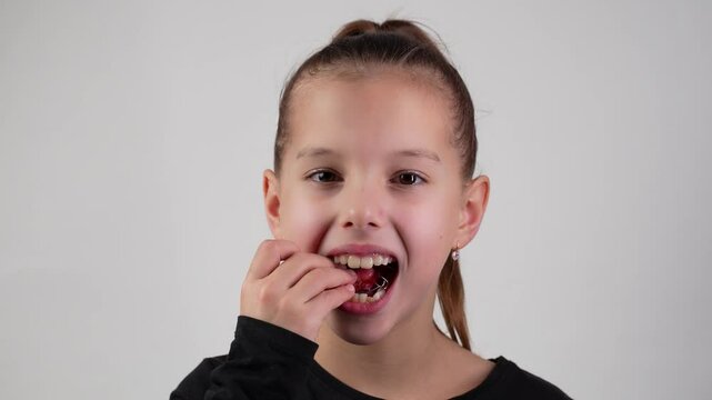 Child wearing braces smiling, looking at camera, close-up. Girl with dental braces or teeth retainers for teeth correction