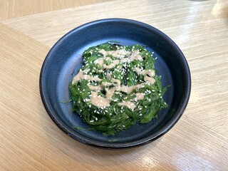 Seaweed salad in Goma Dare Sauce with sesame seeds in a bowl on Japanese restaurant table