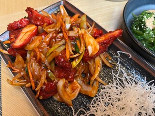 Close up of sliced chicken fillet with hot garlic sauce with vegetables and fried glass noodle 