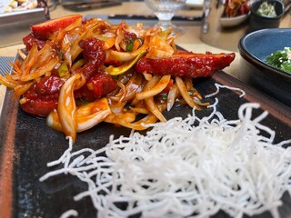Sliced chicken fillet with hot garlic sauce with vegetables and fried glass noodle 