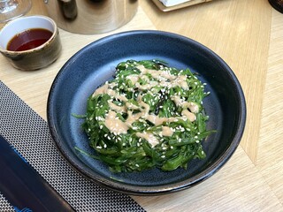 Seaweed salad in Goma Dare Sauce with sesame seeds in a bowl on Japanese restaurant table