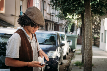 Naklejka premium Teenager boy using the mobile phone outdoors