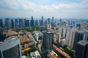 Fototapeta premium Urban skyline reflecting in calm water during late afternoon with clouds in the sky