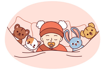 Newborn baby sleeps soundly in bed among toys or sucks on pacifier for concept of child care. Innocent newborn with toys lies under blanket and falls asleep after feeding infant formula in morning