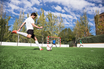 Football player shooting the ball on football field