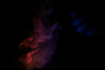 Fototapeta premium colorful smoke on dark background. Color steam on a black background. Red and blue smoke. Copy space.