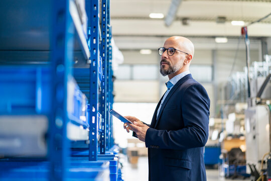 Businessman with tablet in factory storehouse