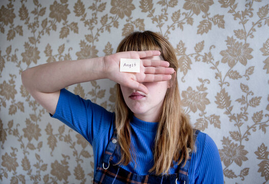 Student holding a hand in front of her eyes, a note with the word fear on her hand