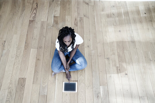 Woman sitting on the floor using digital tablet