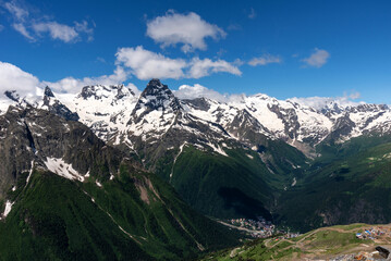 Picturesque summer landscape in Dombay with amazing snow-capped peaks of North Caucasus Mountains. Mountain ski resort in Karachay-Cherkessia, Russia