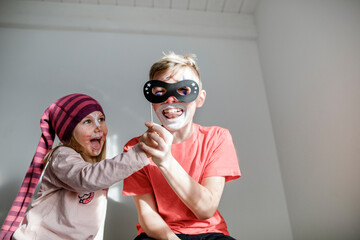 Brother and little sister made up for carnival having fun together