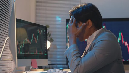 Stressed professional analyzing declining stock market data, hand on forehead, reflecting financial pressure and market volatility