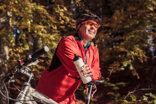 Man with mountainbike having a break in forest