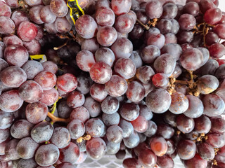 pile of fresh purple grapes for sale at the market