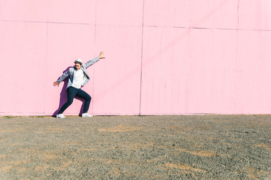 Young man in front of pink construction barrier, feeling trapped