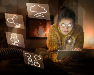Young woman using tablet at home surrounded by internet symbols