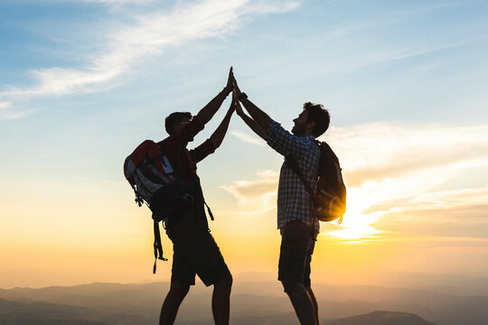 Italy, Monte Nerone, two happy and successful hikers in the mountains at sunset
