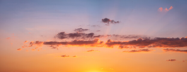 Panoramic background of beautiful sky at sunset with clouds glowing