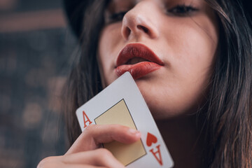 Woman holding ace card near her mouth. Poker or other card games