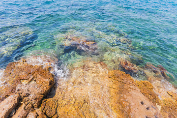 Obraz premium Crystal Clear Waters and Rocky Shoreline in Greece, Sunny Summer Day