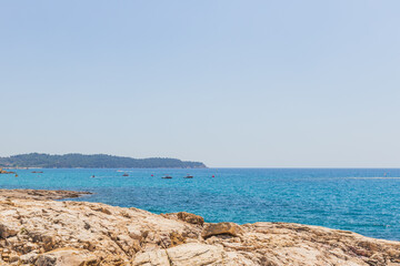 Crystal Clear Waters and Rocky Shoreline in Greece, Sunny Summer Day