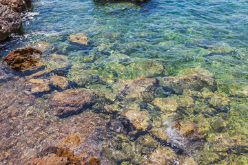 Vibrant Rock Formation in Sunlit Clear Coastal Waters