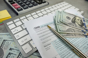 Obraz premium US 1040 form or US Individual income pen calculator dollar on desk. Accounting documents taxation