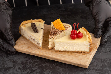 classic cheesecake decorated with cherries, chocolate and cookies on a dark background