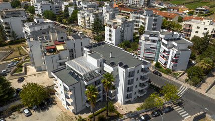Aerial view of white buildings on the outskirts of a city.