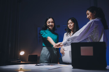Business people working late at laptop in highrise office