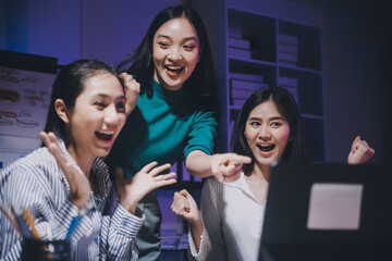 Business people working late at laptop in highrise office