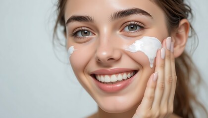 Close-up portrait of a young woman applying a luxurious facial cream, showcasing her radiant skin and beautiful smile.